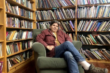 Dan Weinstein, owner of The Iliad Bookstore sits surrounded by books.