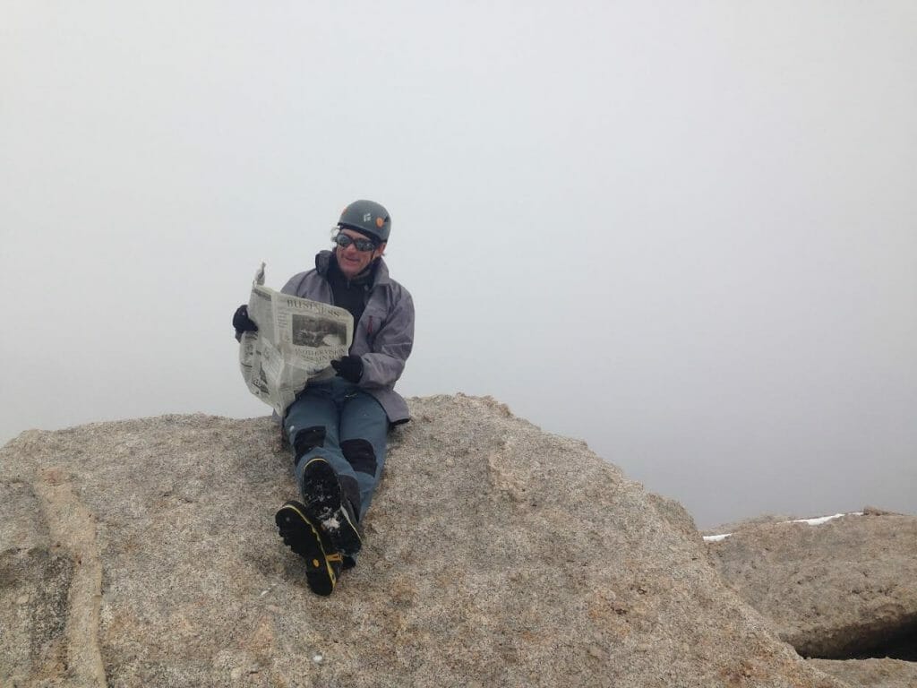 Geoff Mohan reading the Business section of the L.A. Times while atop Lone Pine Peak.