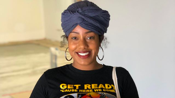 Asha Grant carries a clear plastic bin full of books.