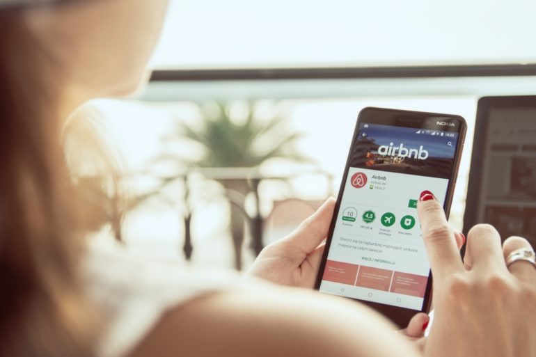 A person installs an Airbnb application on their smartphone.