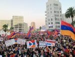 A photo at dusk of thousands of people holding Armenian flags and pro-Artsakh signs on a street in Los Angeles.