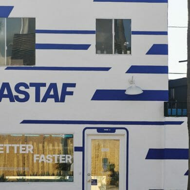 A storefront painted white with blue strips, emblazoned with "FASTAF."