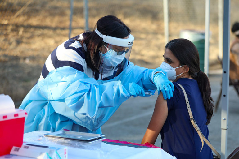 A health care worker receives a COVID-19 vaccination.
